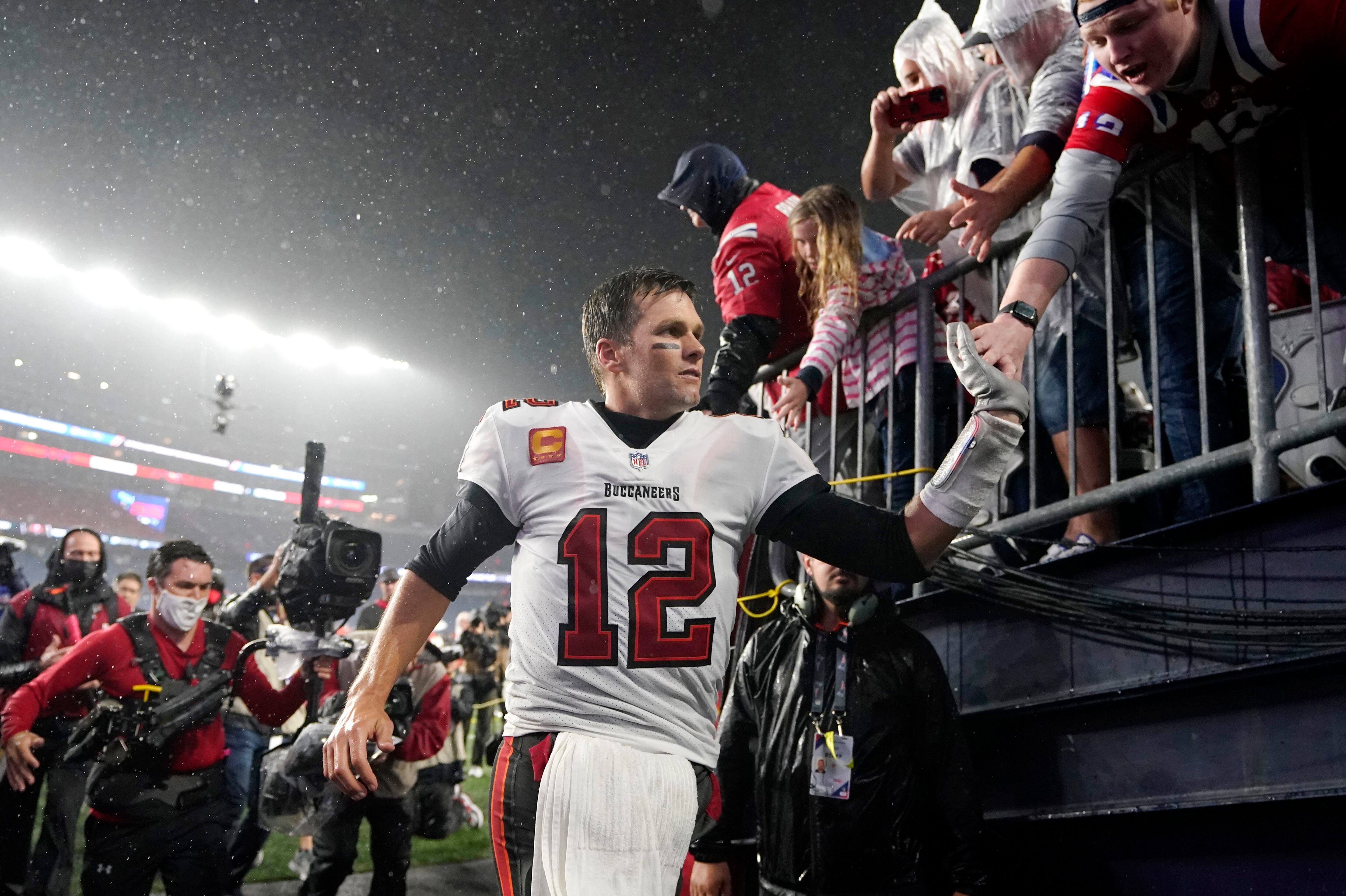 Tampa Bay Buccaneers quarterback Tom Brady (12) puts on his helmet during  the second half of an NFL football game against the New England Patriots,  Sunday, Oct. 3, 2021, in Foxborough, Mass. (